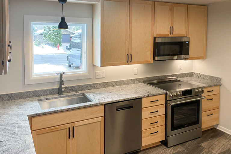 Contractors installing new wooden cabinets during a kitchen remodel project.